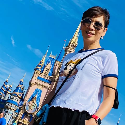 Hui-Fen smiling in front of a castle on a bright day
